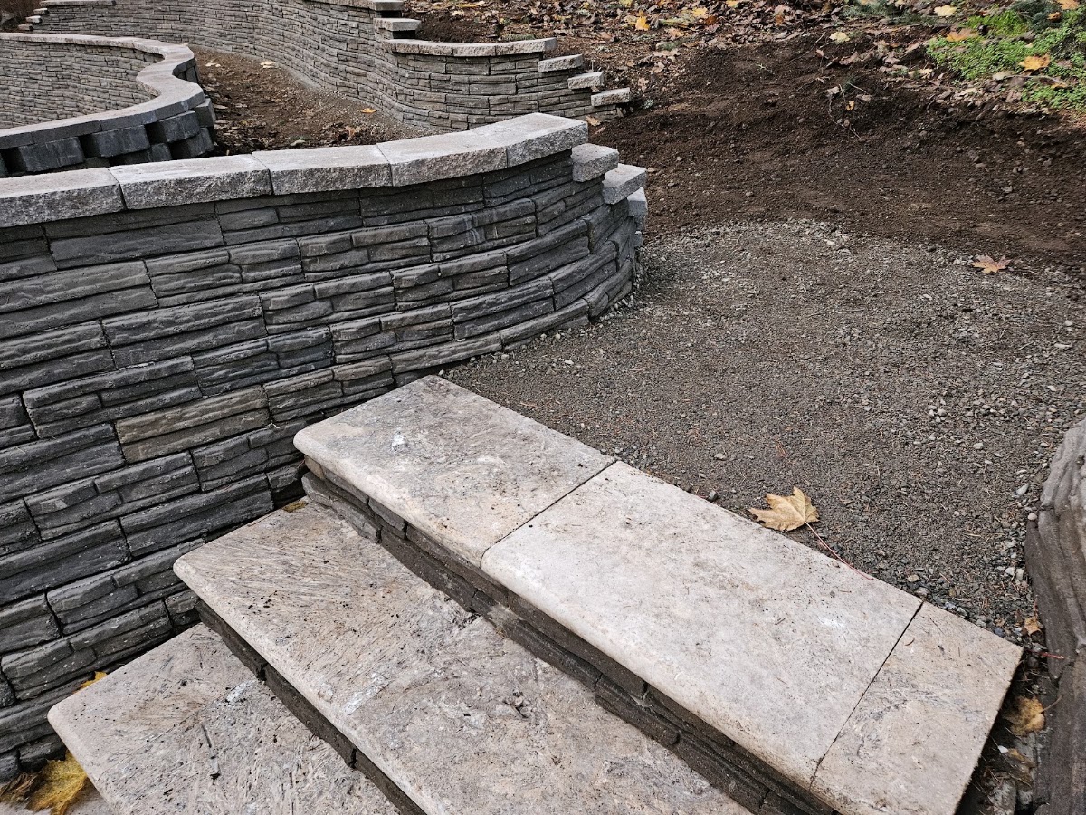 Curved two-tone stone retaining wall with built-in steps